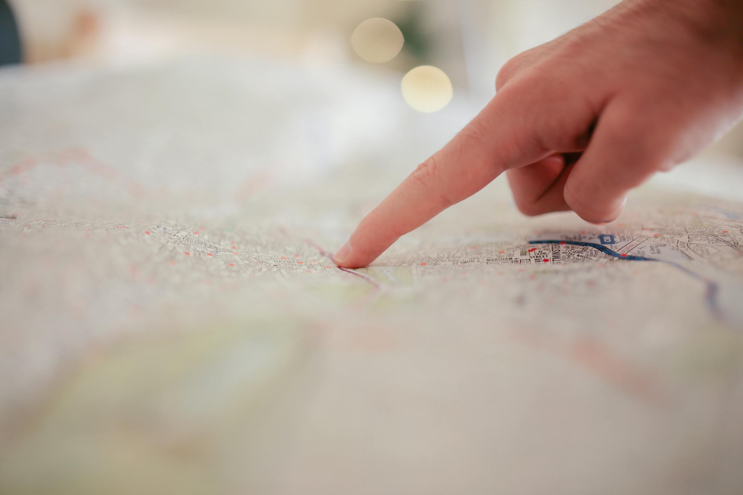 a finger pointing at a map